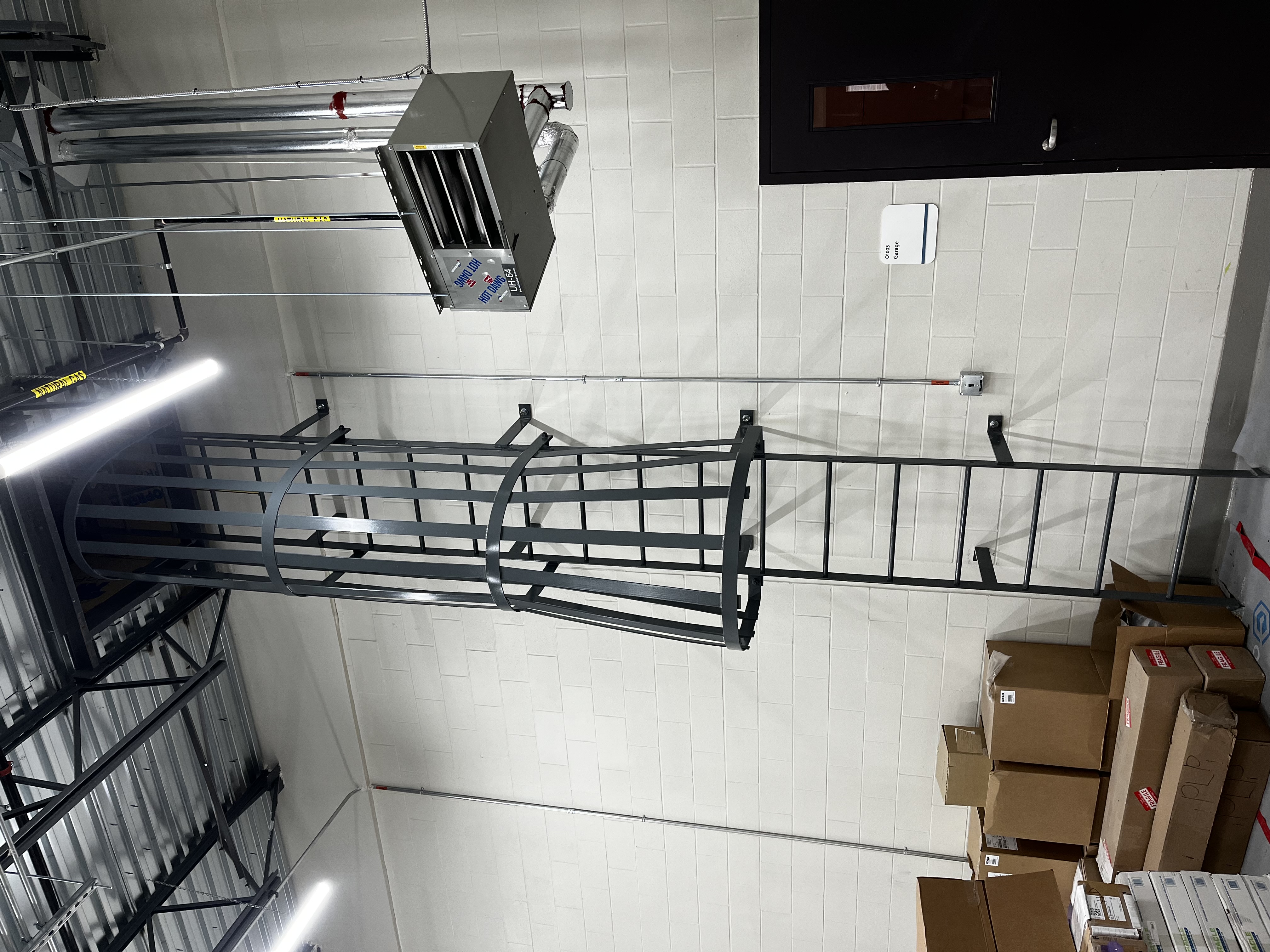 Steel caged walk through fixed access ladder